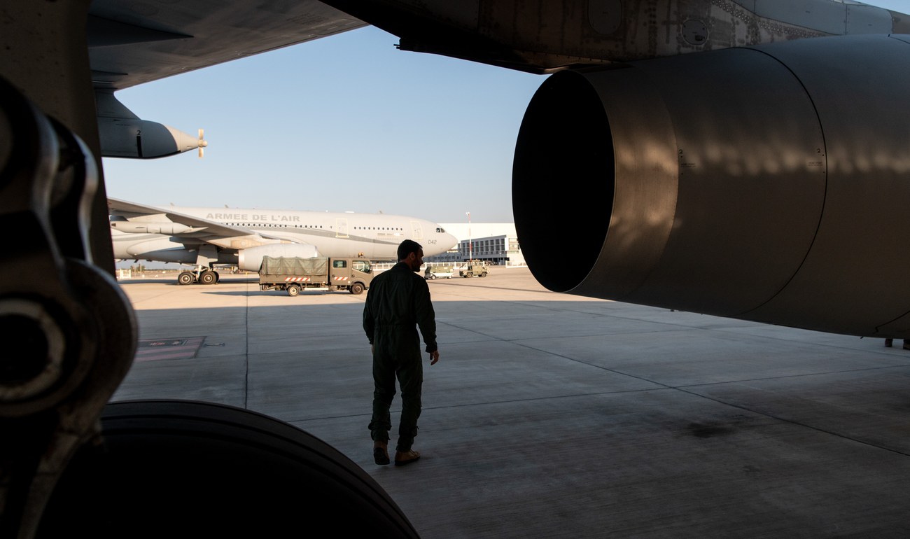 Un militaire marche sur le tarmac sous l'aile d'un avion ravitailleur de l'Armée de l'Air et de l'Espace